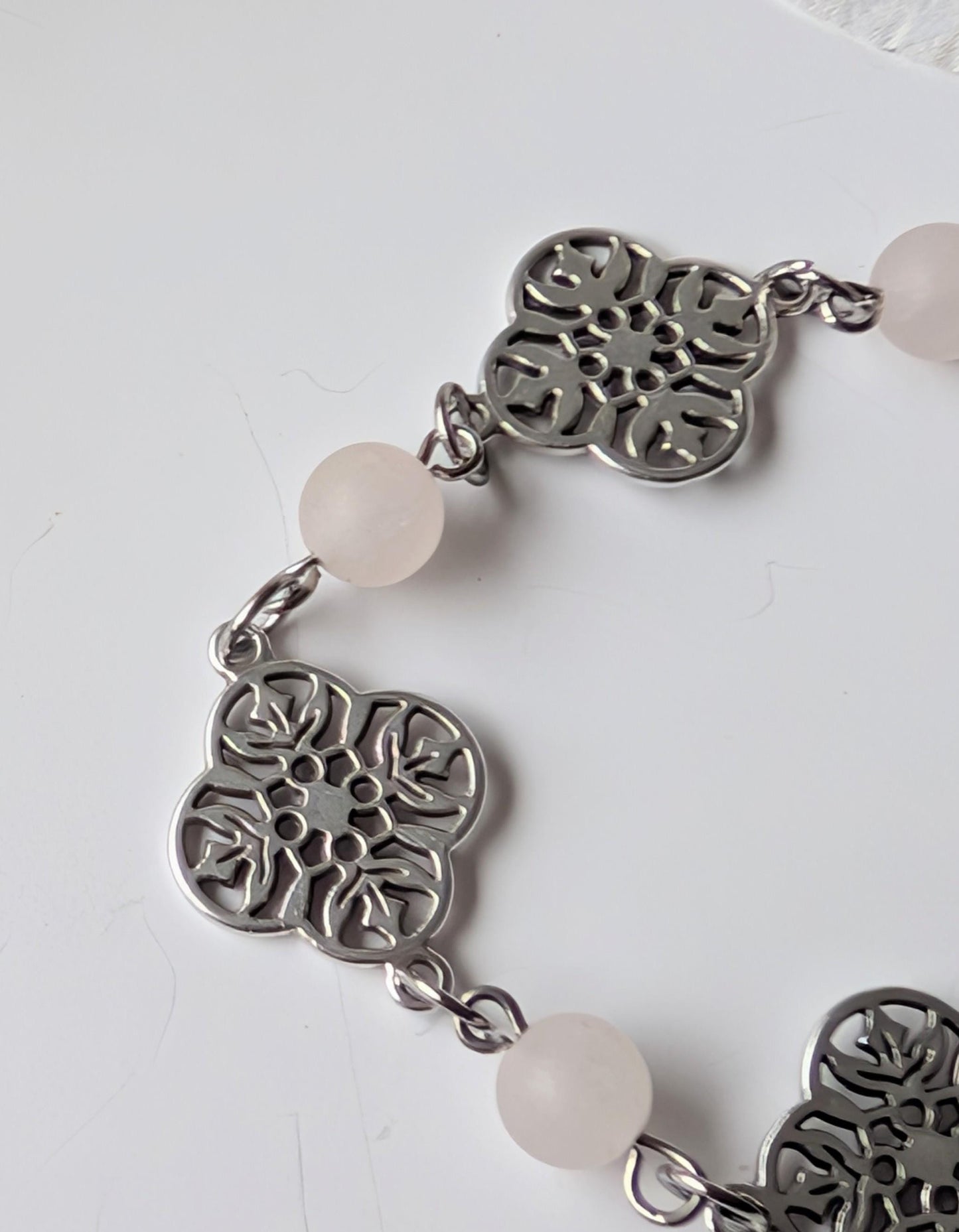 Delicate bracelet with ornate connectors and frosted rose quartz beads