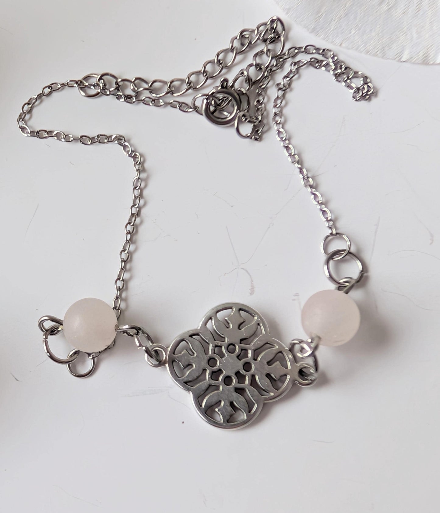 Delicate bracelet with ornate connector and 2 frosted rose quartz beads