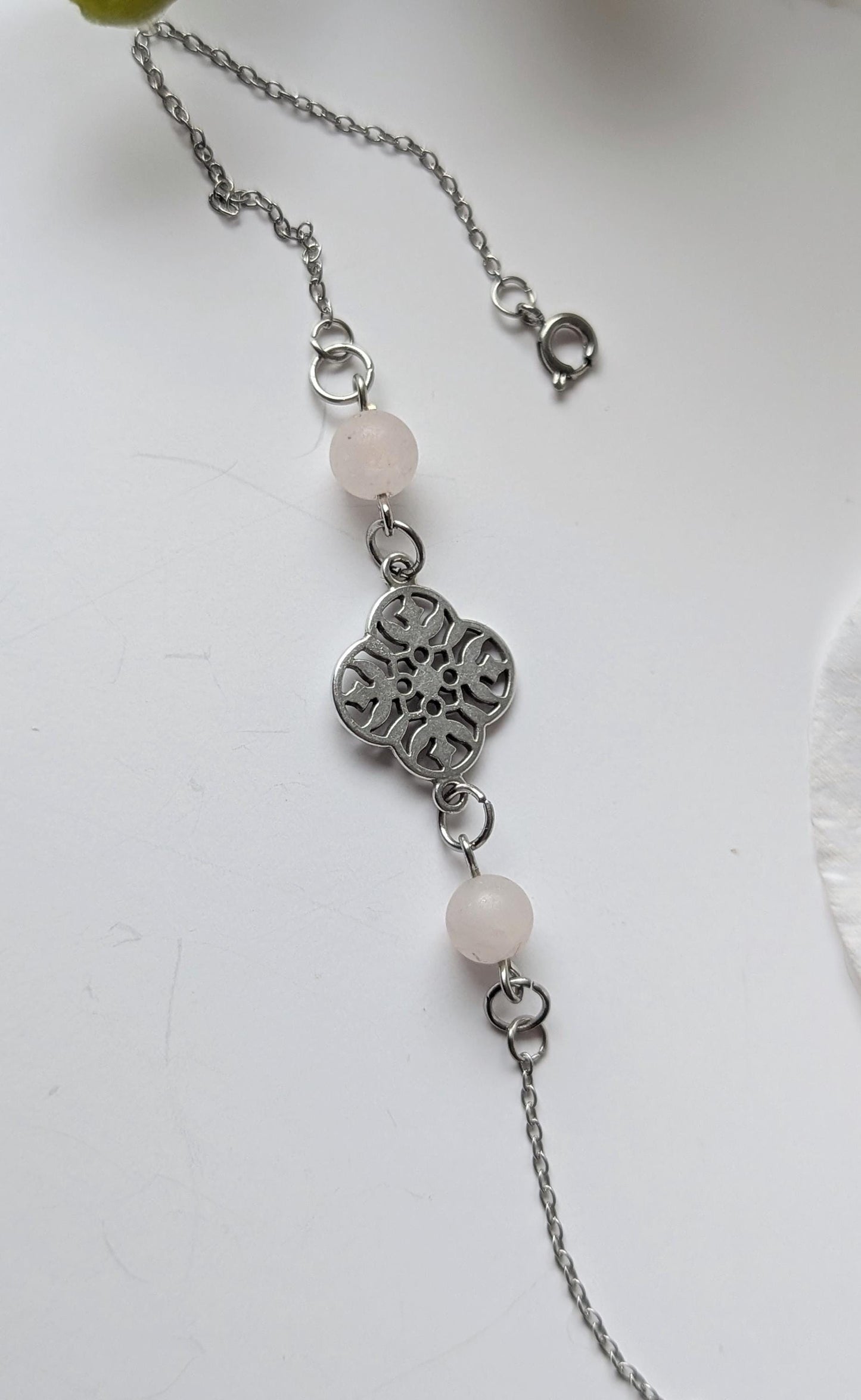 Delicate bracelet with ornate connector and 2 frosted rose quartz beads